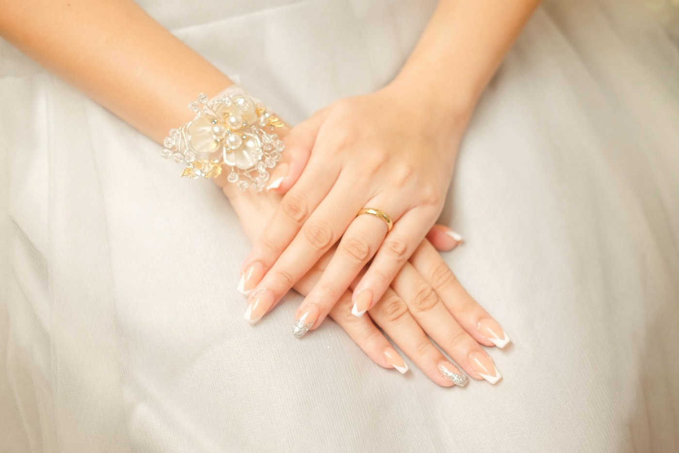 Cảm hứng nails cưới kiểu French nhẹ nhàng, đôi tay đặt trên váy trắng